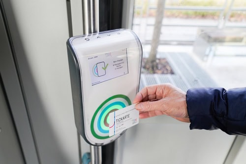 Ticket für den öffentlichen Nahverkehr wird an einen Scanner in einem Fahrzeug gehalten